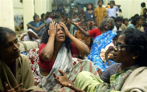 Auf diesem Aktenfoto vom 27. Dezember 2004 betrauern Menschen, die durch den Tsunami vertrieben wurden, ihre Verluste, während sie in einem Hilfslager in einem Tempel in Varichikudi, etwa 200 Kilometer (125 Meilen) südlich von Madras, Indien, sitzen. AP